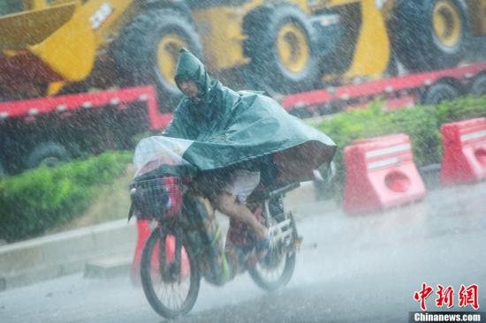 图为南宁市民冒雨出行。中新社发 冯抒敏 摄