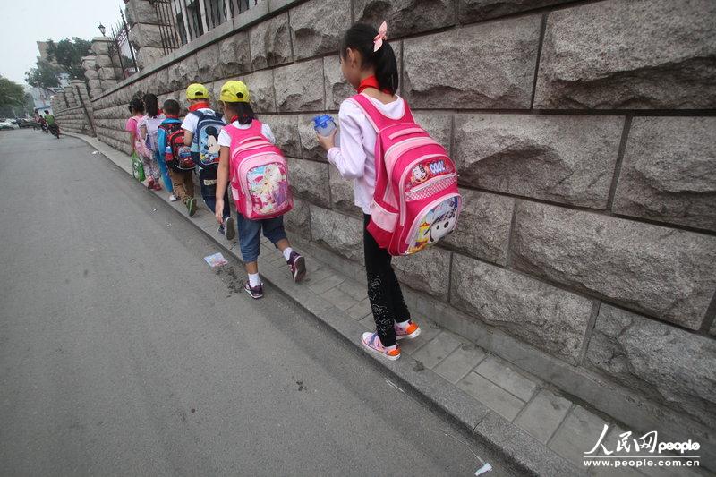 2013年09月11日，济南运署街上，小学生走史上“最窄人行道”上学。