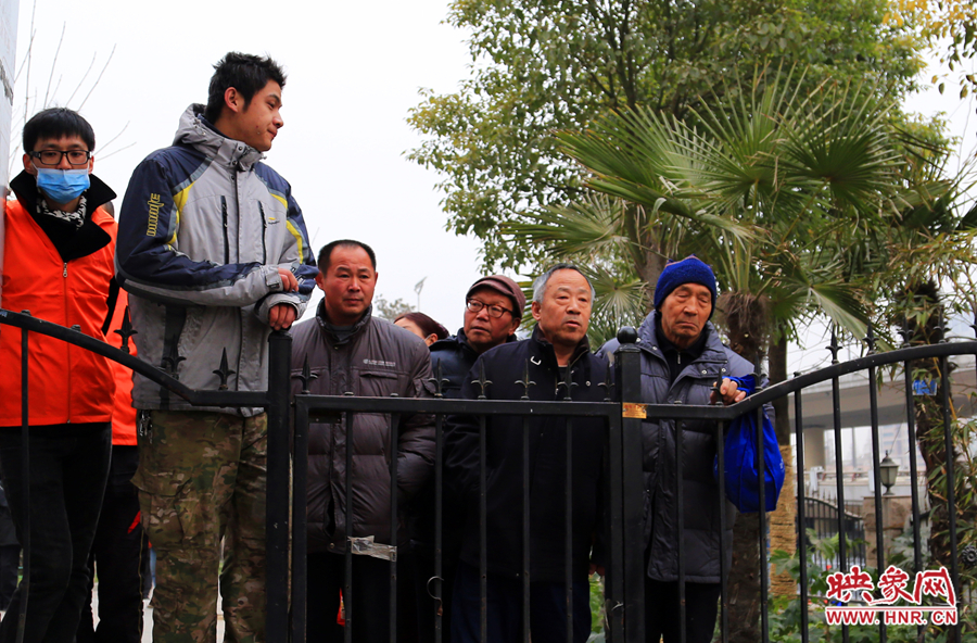 没能赶上第一批腊八粥的市民在施粥点外等待第二批腊八粥的到来