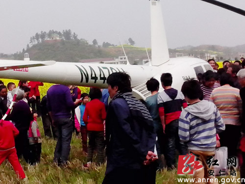 直升机主在空中赏花后停泊在油菜花旁的空地上