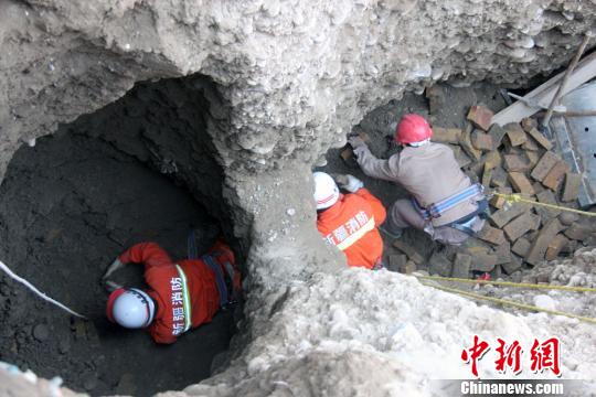 图为当地救援人员用手挖泥土。　达林塔　摄