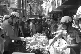 7月11日，浏阳市北正中路，执法人员暂扣张海的水果。这是浏阳市城管局拍摄的执法现场图。