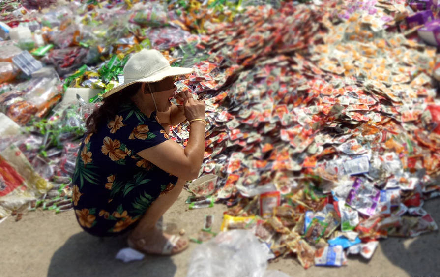 过期食品倒路边 市民争相捡吃其余重回市场