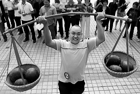 节会现场，一位瓜农正在表演西瓜举重。