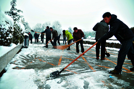 干部职工走上街头清扫积雪保畅通