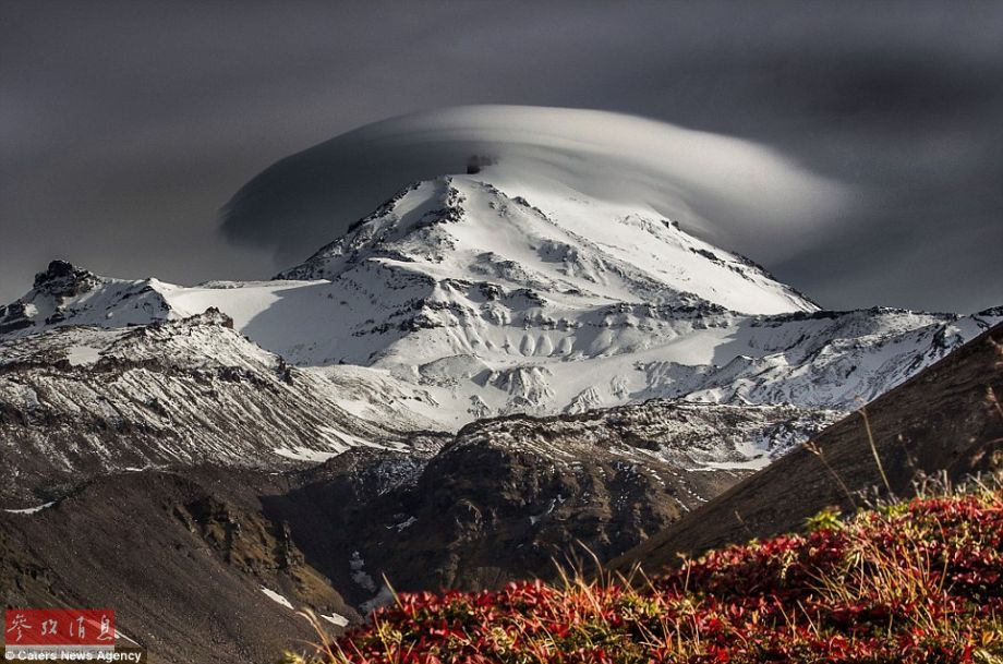 火山上笼罩着类似于外星飞碟形状的云彩，场景犹如科幻大片。