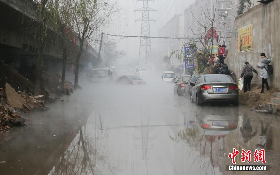 水漫上路面挡住了行人的去路，市民从侧面的斜坡通过。