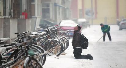 小伙子跪在楼前，一直抬头看着楼上。 孙立国/摄