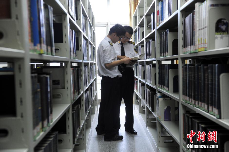 5月8日，武汉轻工大学保安吴涛与江力在图书馆交流学习。中新社发 张畅 摄